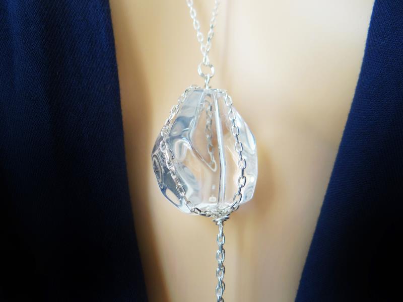 <p>Pendentif en cristal de roche de 3 cm taillée de façon irrégulière, monté sur une chaine en argent accompagné de 3 petites perles en cristal de roche.</p>